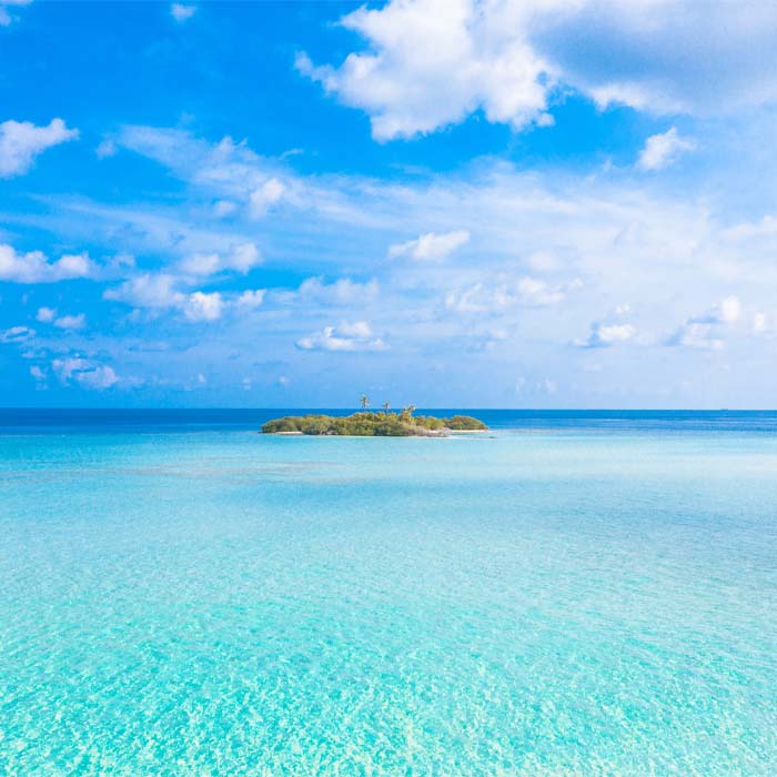 tiny island surrounded by crystal clear ocean waters