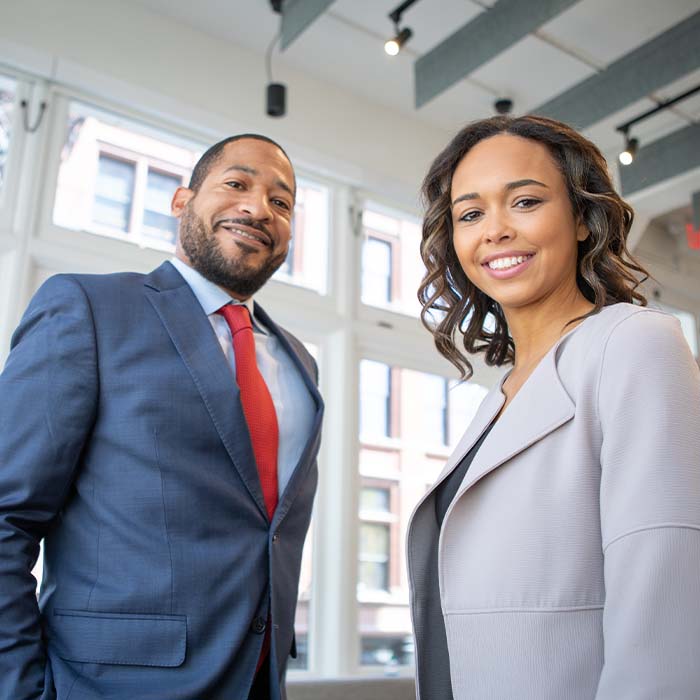two professional people posing wearing business suits
