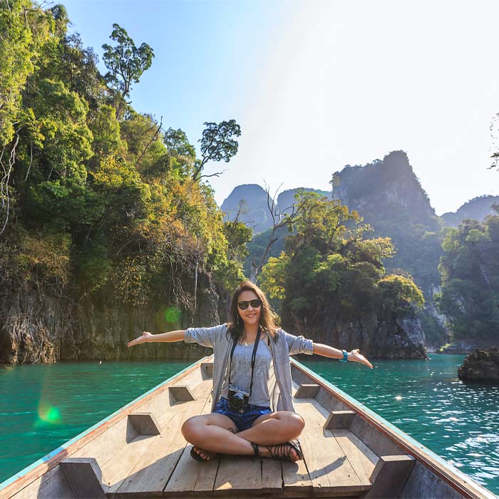 a young woman sitting on a boat enjoying the nature around her